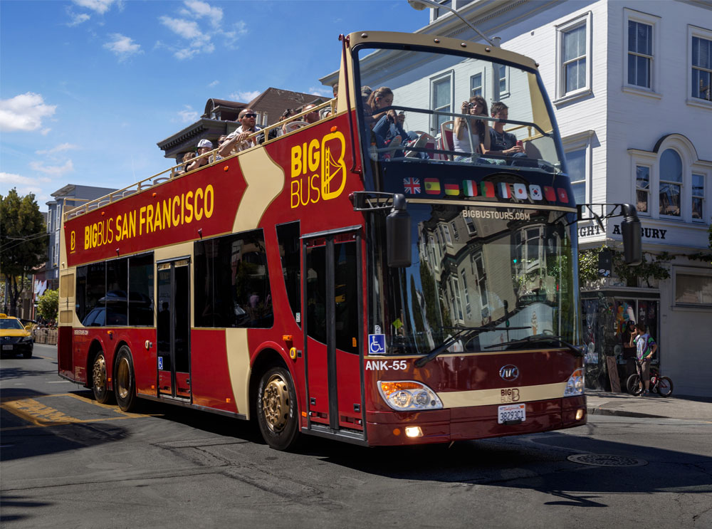 A Big Bus Tour drives through Haight Ashbury in San Francisco