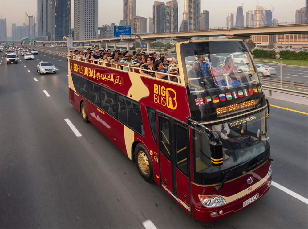 Big Bus Tours Sightseeing-Bus, der auf einer Autobahn in Dubai fährt
