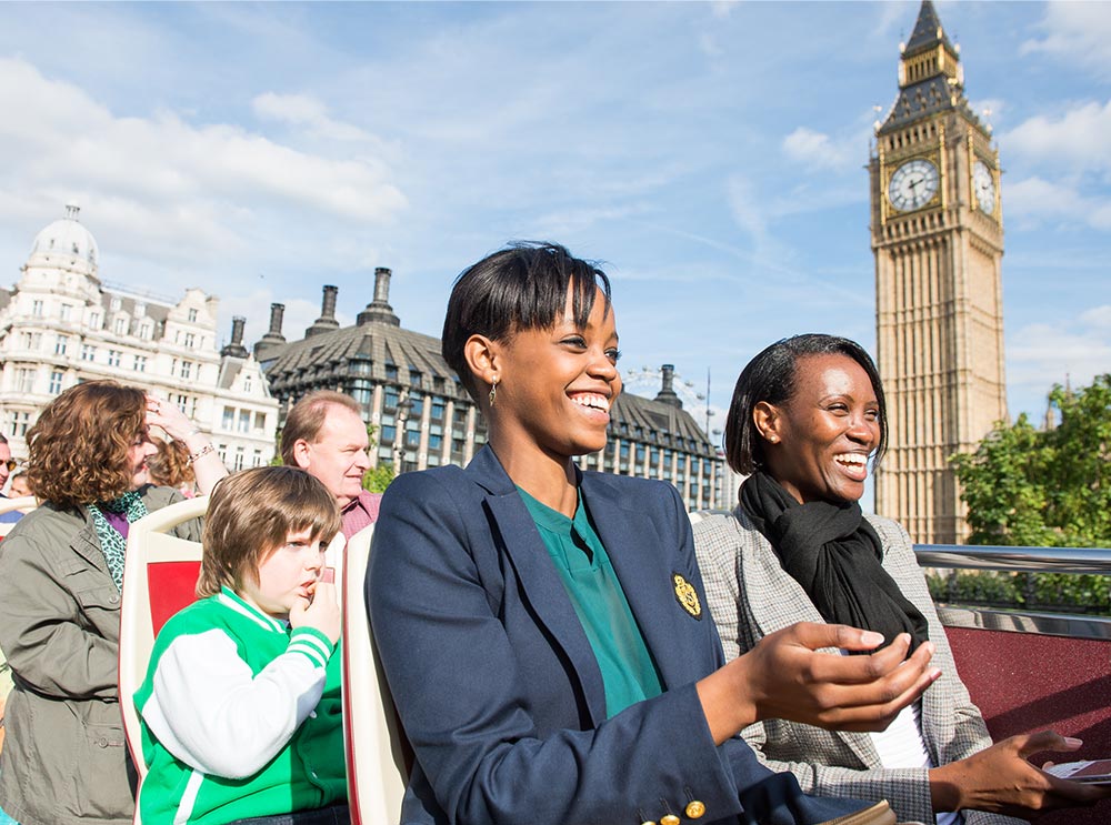 Lächelnde Frauen beim Anblick von Big Ben von der Big Bus Tour aus