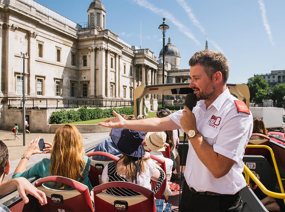 Passengers on board the bus tour in London listening to the live tour guide