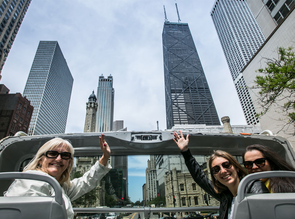 Amigas en el piso superior de un autobús turístico en Chicago