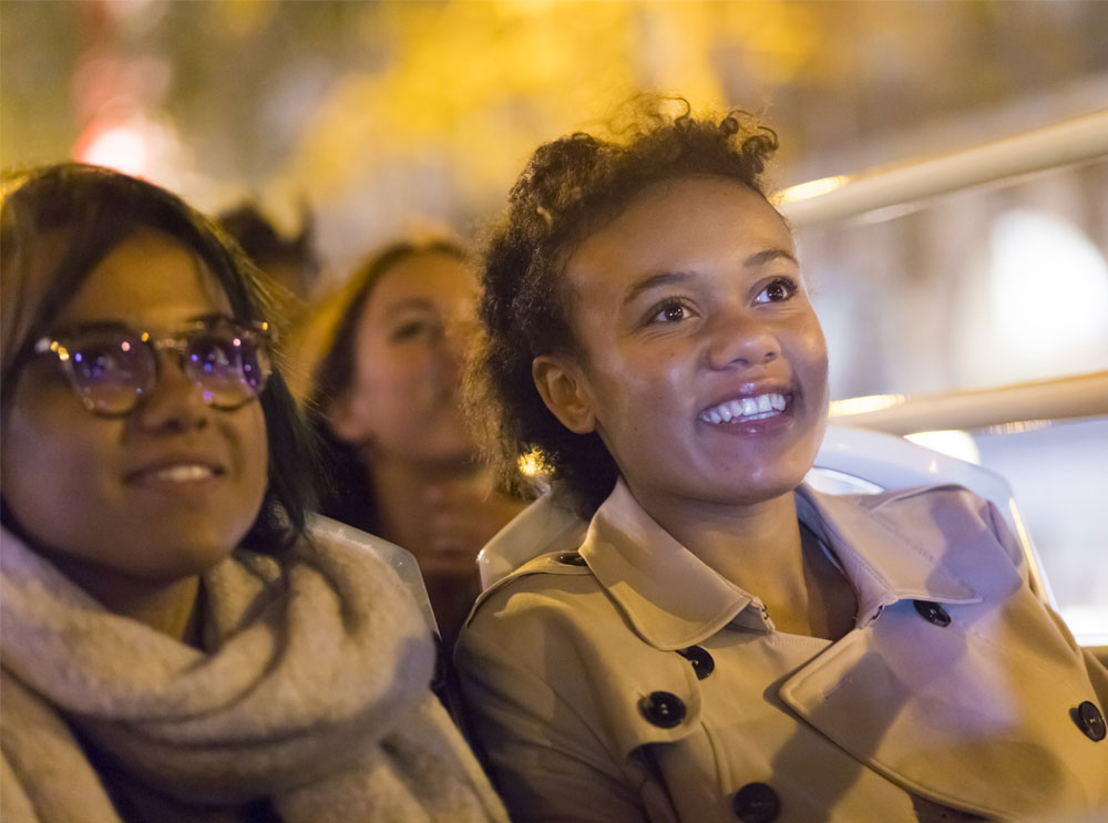 Passengers on the top deck of the Big Bus in Madrid at night