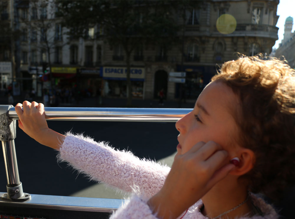 Ragazza che ascolta il commento audio durante un tour del Big Bus
