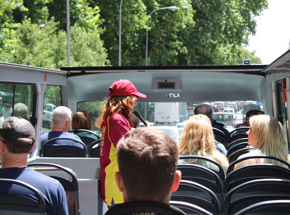 Guía en vivo en el piso superior del recorrido en autobús