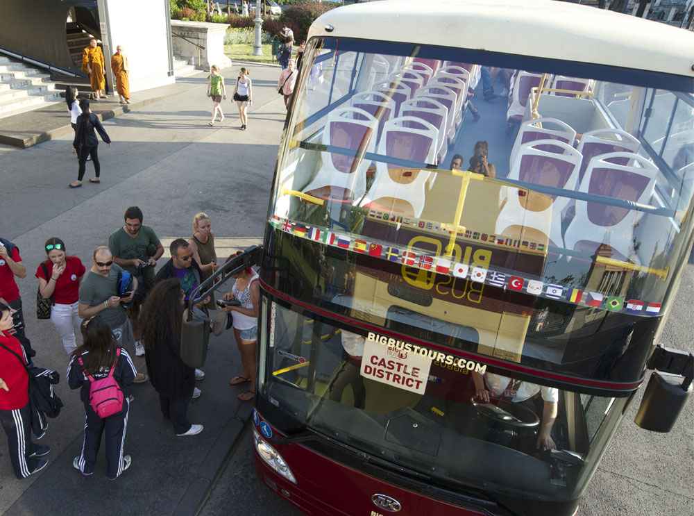 Passagiere steigen in einen Bus von Big Bus Tours ein