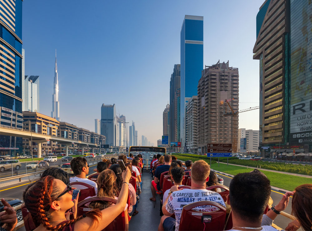 Passagiere auf dem obersten Schreibtisch einer Sightseeing-Bustour in Dubai
