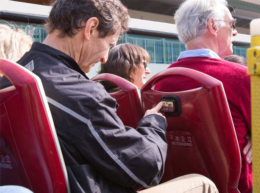 Man using audio commentary on Big Bus Tour