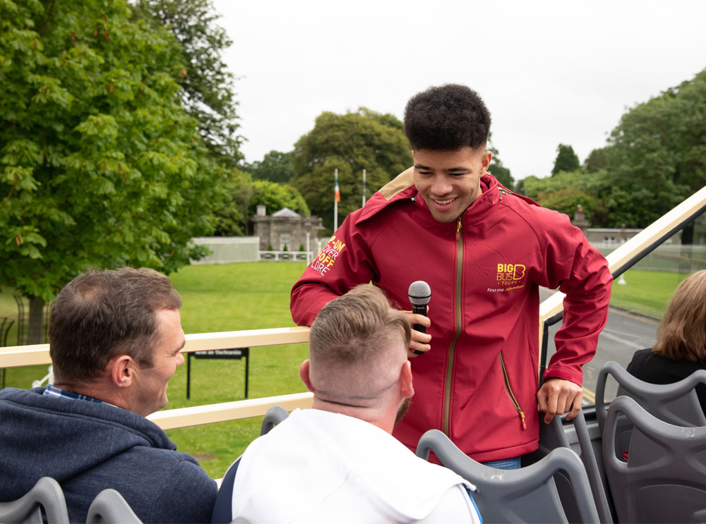 Live guide talking to passengers on an open top bus tour