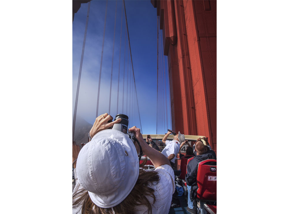 Pasajero en un autobús turístico descapotable que pasa por el puente Golden Gate