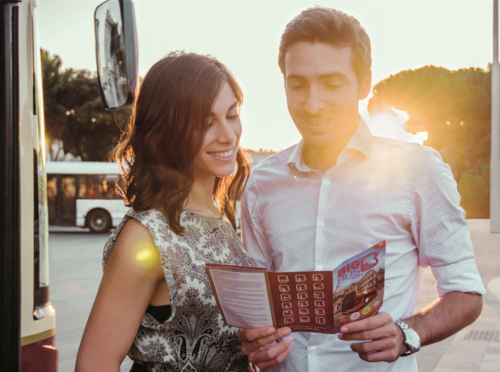 Couple reading Big Bus Tours leaflet in Rome