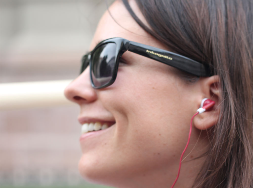 Mujer escuchando audioguía a través de auriculares rojos