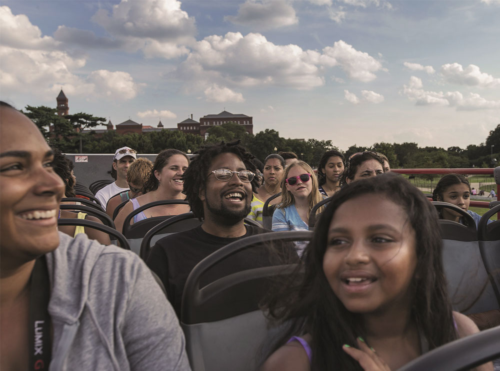 Passengers on the top deck of a sightseeing tour bus