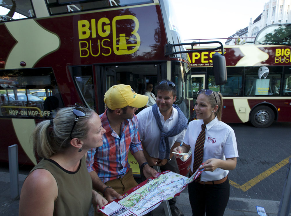 Passagiere im Gespräch mit einem Mitarbeiter von Big Bus Tours