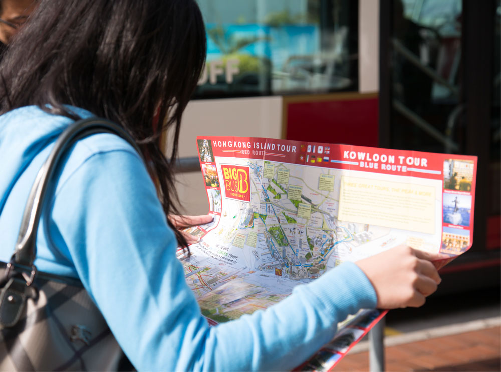 一位女士在巴士上阅读 Big Bus Tours 的宣传册