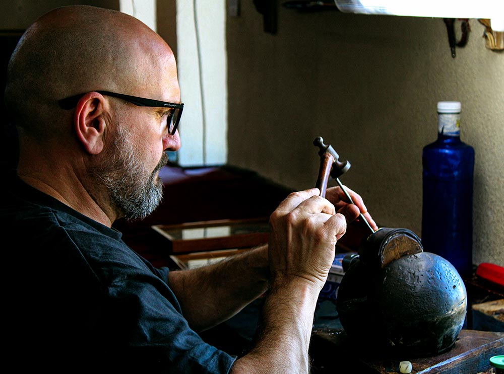 Un hombre trabajando en el taller de fabricación artesanal de espadas de Toledo