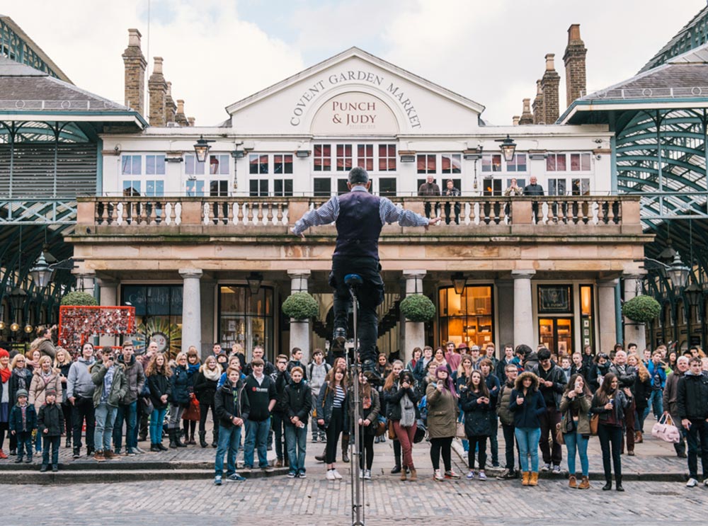 Mann unterhält eine Menschenmenge im Covent Garden