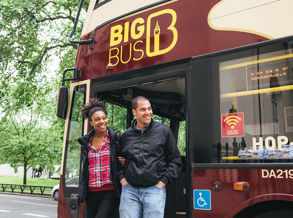 Couple sautant du Big Bus Tour à Londres