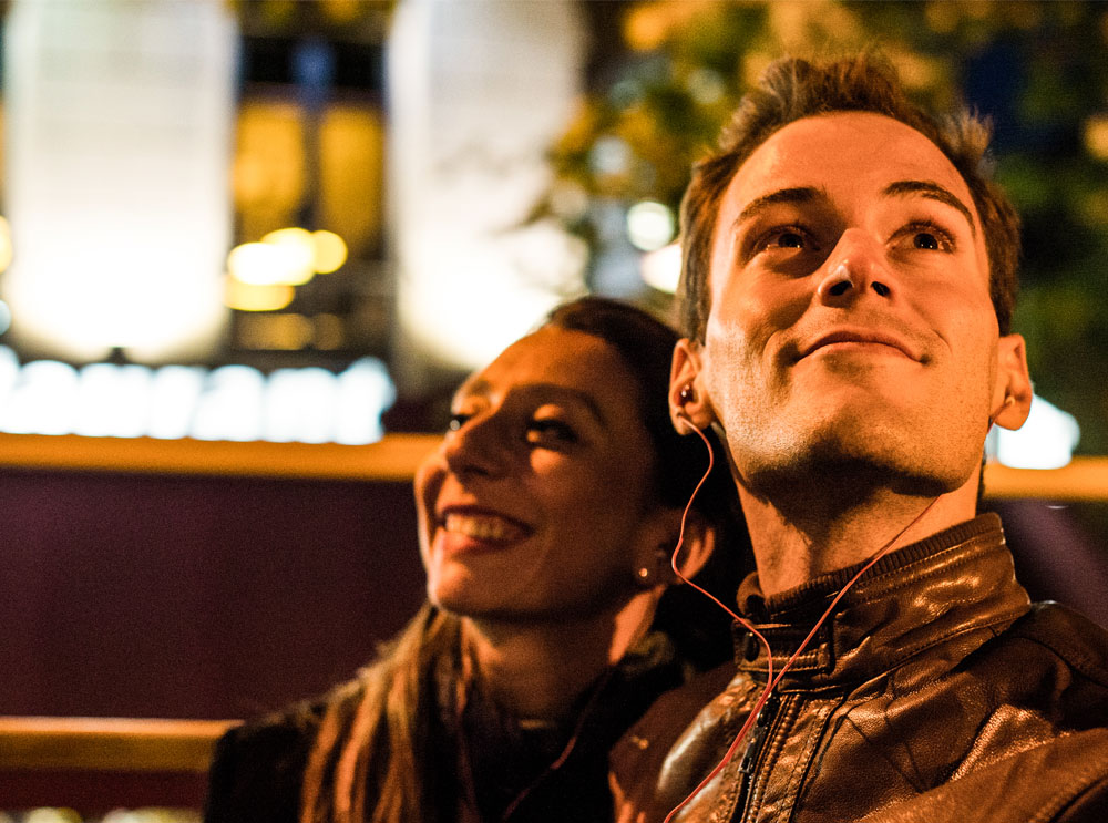 Couple on sightseeing bus tour at night