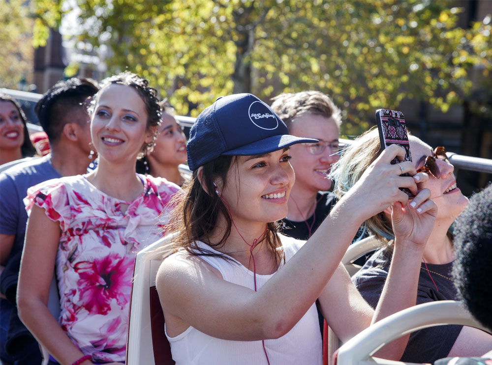 Girl listening to audio guide on the top deck of a sightseeing tour
