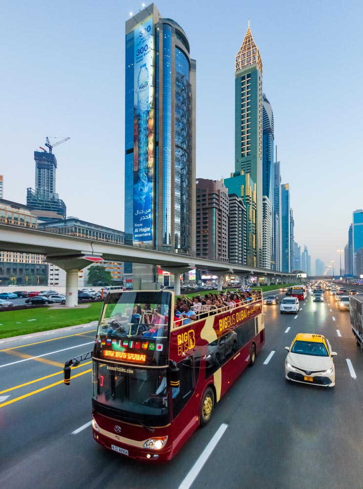 Big Bus Tours Dubai travels along a highway fringed by skyscrapers