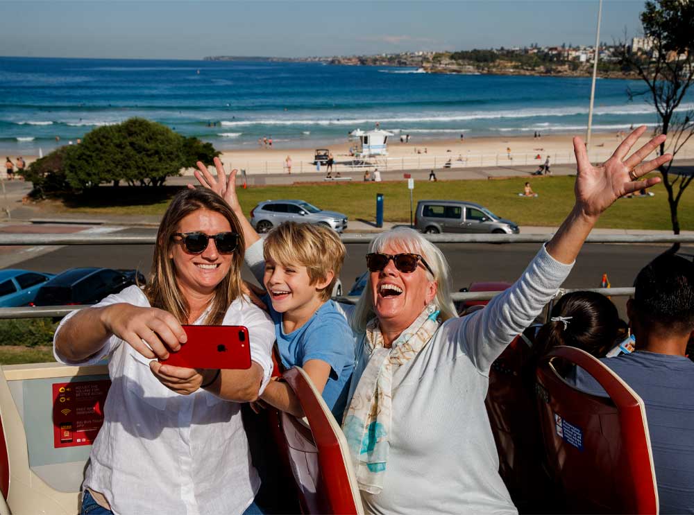 A family takes a bus selfie at Bondi Beach