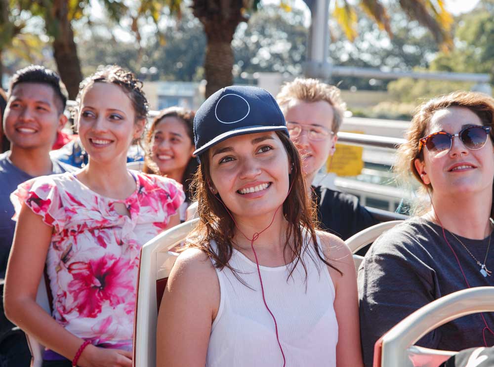 Guest listens to Audioguide on board Big Bus Tours Sydney