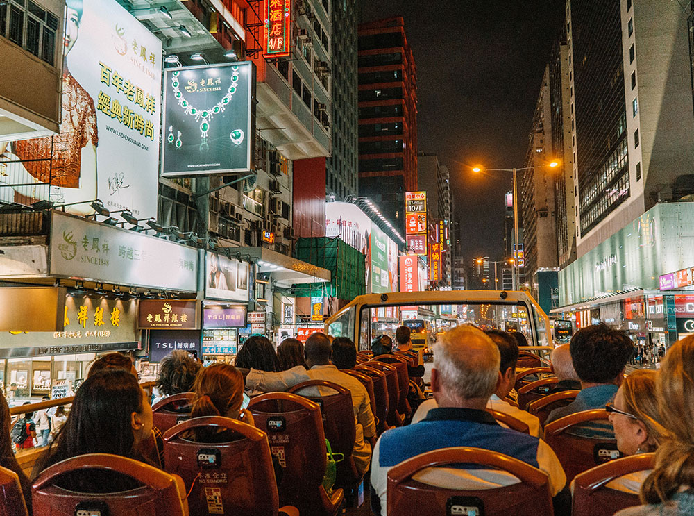 Passengers on top of the Hong Kong Big Bus at night.