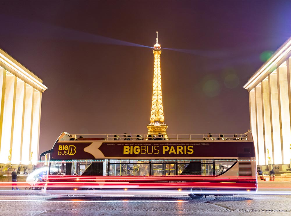 Big Bus Tour estacionado cerca de la Torre Eiffel durante un recorrido nocturno