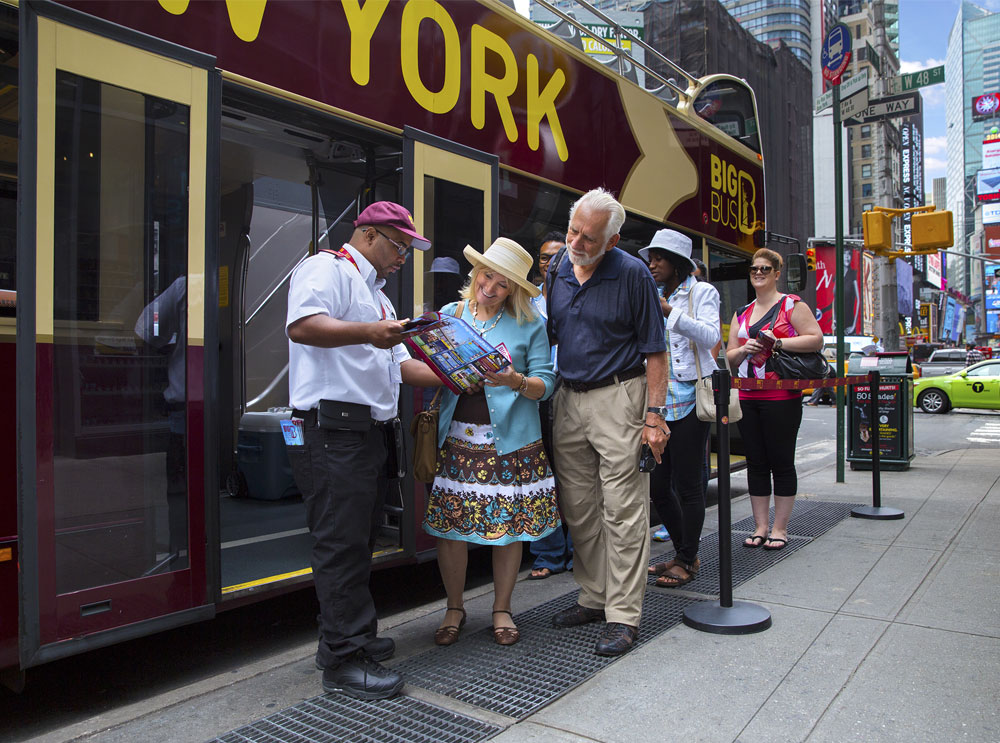 Menschen in New York sprechen mit einem Mitarbeiter von Big Bus Tours
