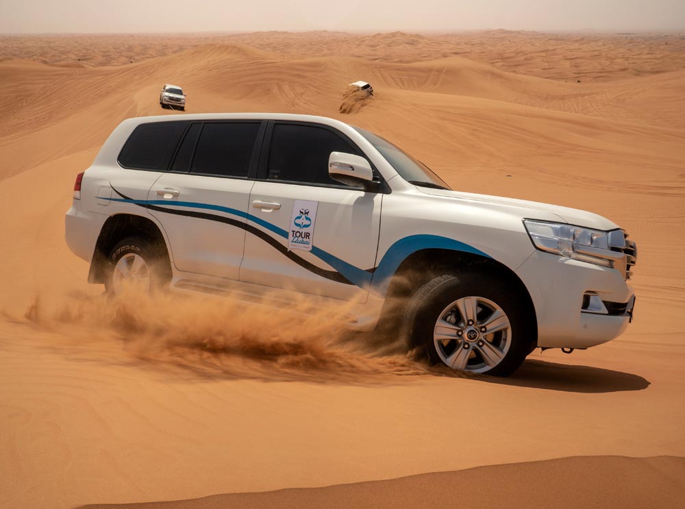 Toyota Landcruiser drivers through the desert sand