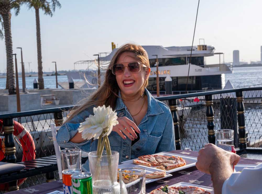 Woman eats pizza on board the The Pirate Ship Sightseeing Cruise