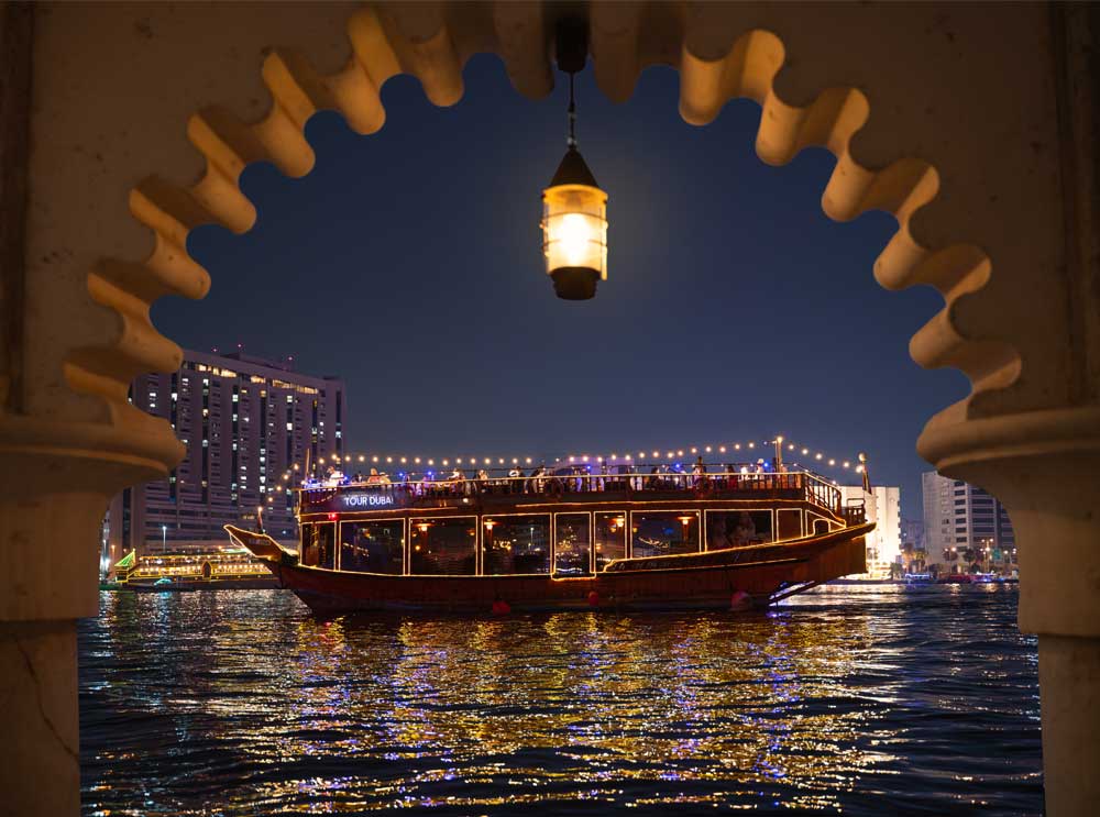 The Dubai Creek Dhow Dinner Cruise viewed through an Arabian archway