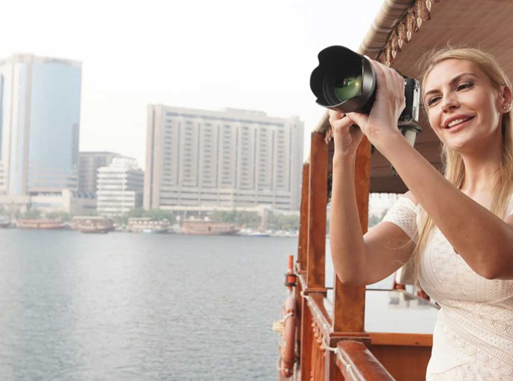 Woman takes photographs from Dubai Creek dhow cruise