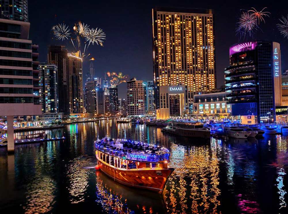 Tour Dubai Marina Dhow Cruise sailing Dubai Marina at night with fireworks