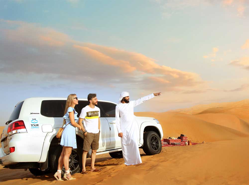 A couple take in the views of the Dubai desert with their guide