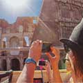 Eine Frau fotografiert das Kolosseum vom Oberdeck von Big Bus Tours Rom aus