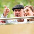 Grandfather pointing at a landmark on a Big Bus sightseeing tour