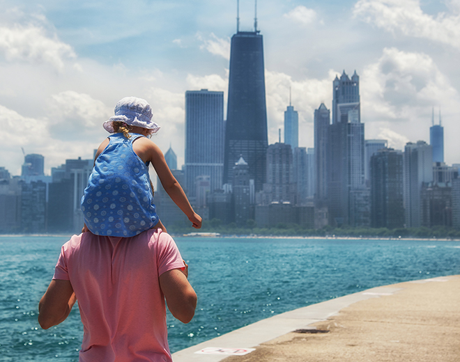 Child sat on dad's shoulders looking out the Chicago skyline