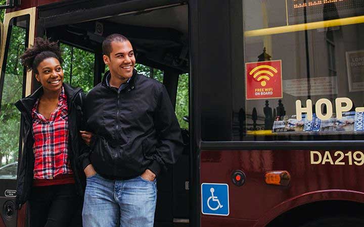Dos personas que bajan de un autobús de Big Bus Tours en Londres en Londres