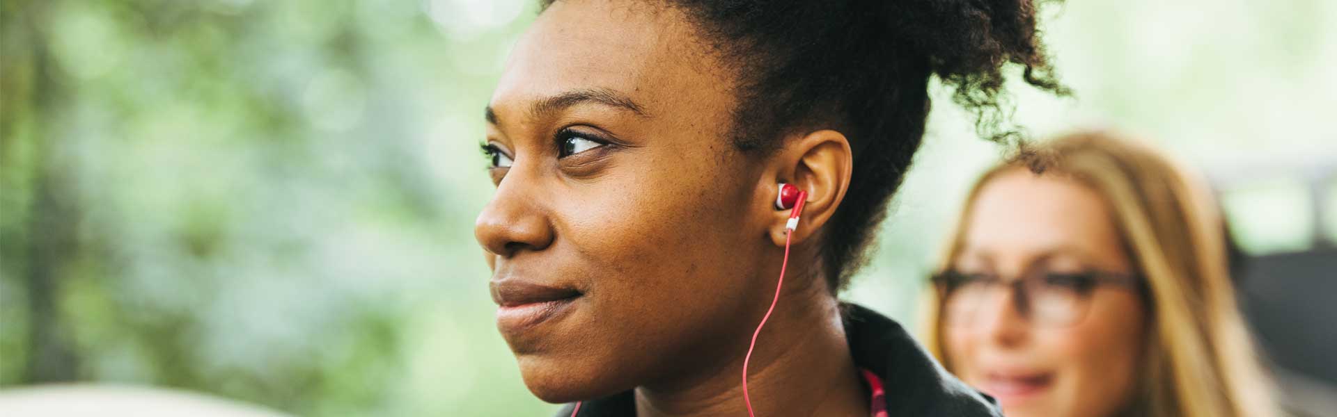 Woman listens to Big Bus Tours pre-recorded commentary via red headphones