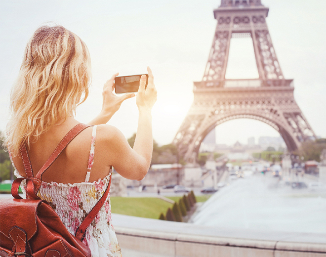 Señora tomando una foto de la Torre Eiffel